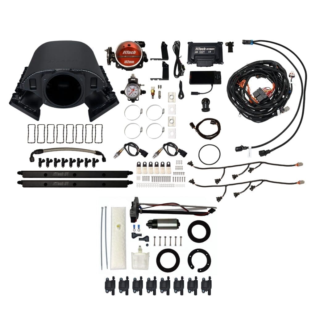 Automotive engine parts and accessories laid out.
