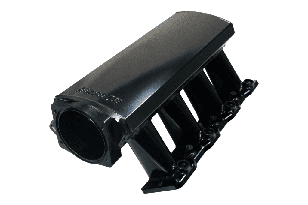 Black automotive intake manifold on white background.