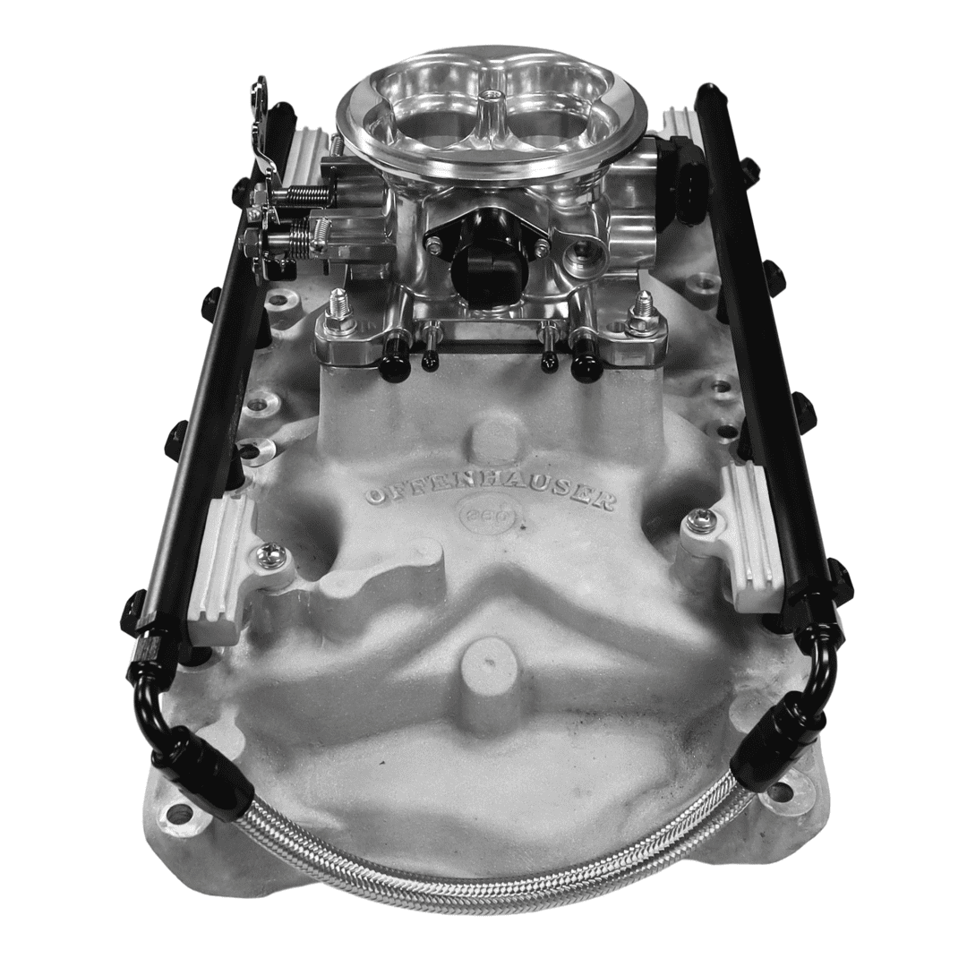 Engine intake manifold with carburetor and hoses.