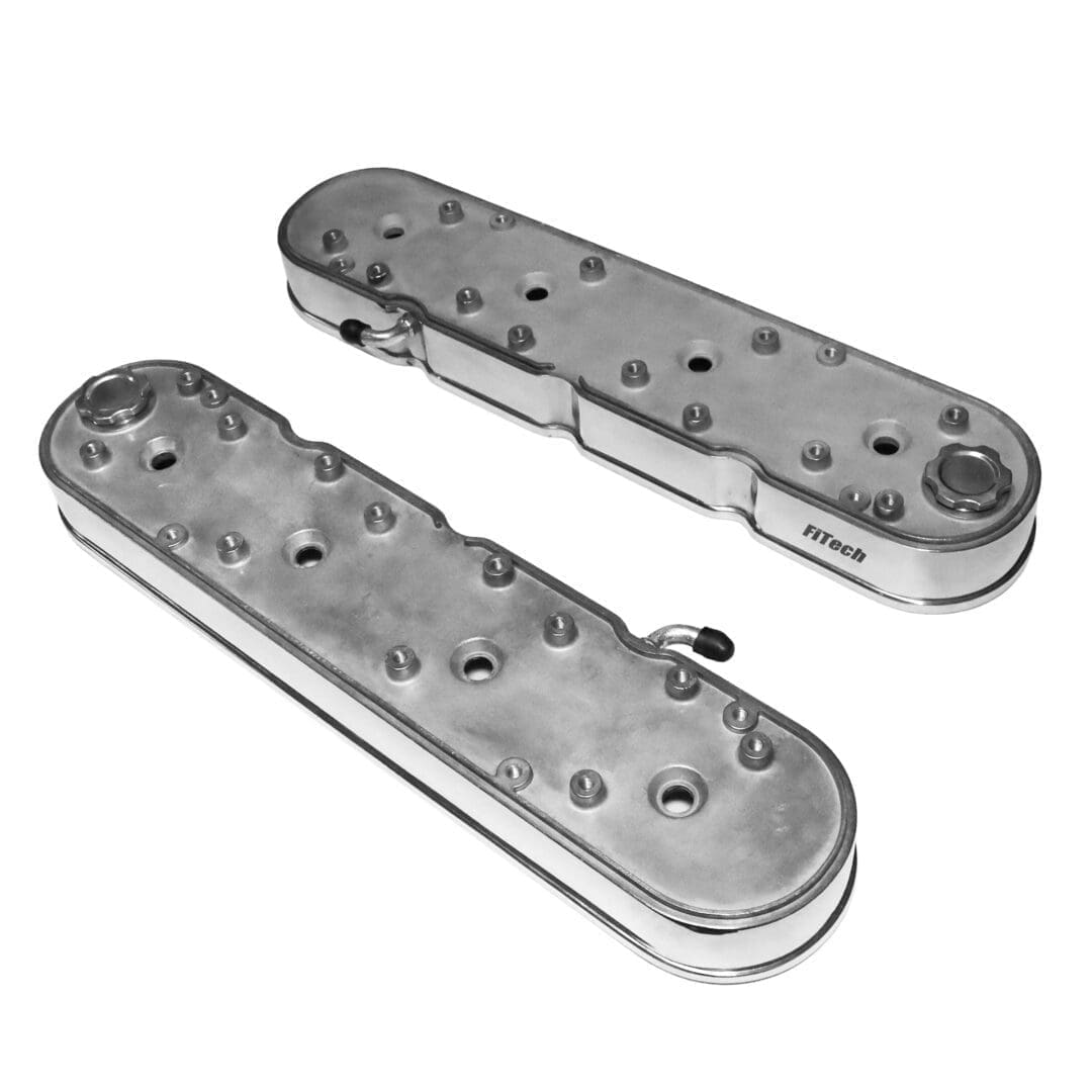 Two silver automotive engine valve covers.