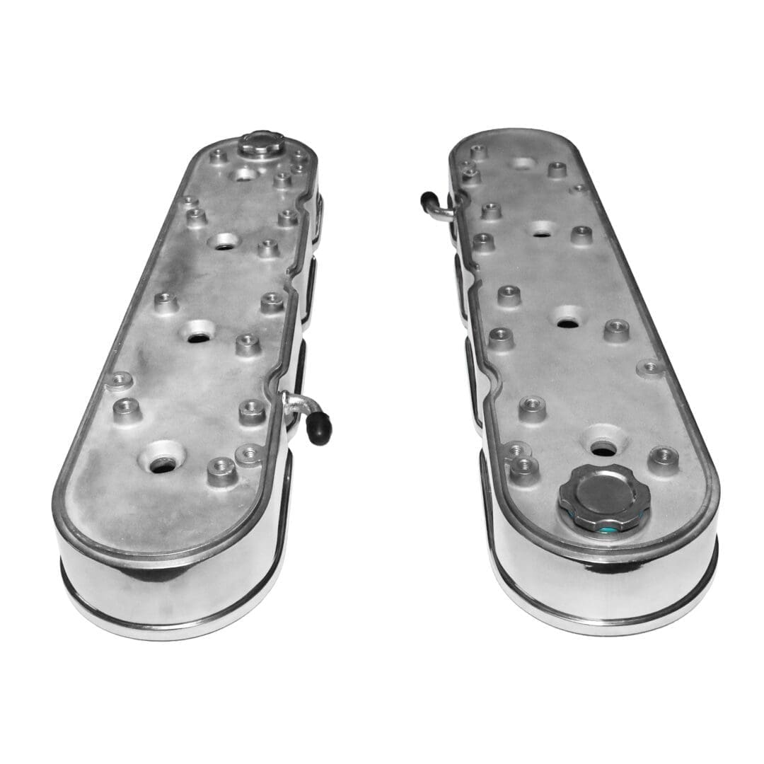 Two metal engine valve covers, isolated.